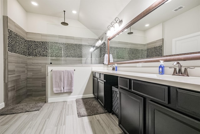 bathroom featuring tiled shower and vanity