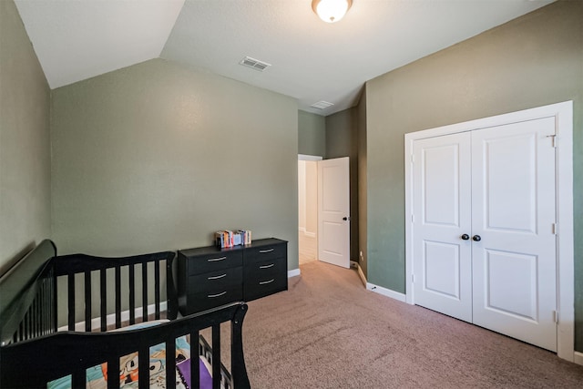 bedroom with vaulted ceiling, a closet, and carpet floors