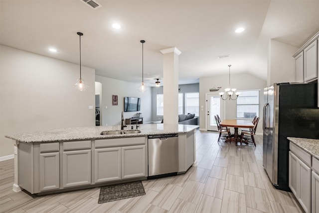 kitchen featuring gray cabinets, stainless steel appliances, hanging light fixtures, light stone counters, and sink