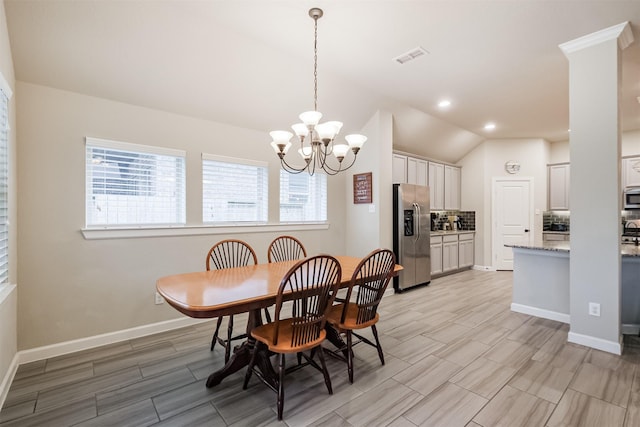 dining area featuring a chandelier and lofted ceiling