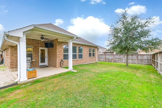 rear view of property featuring ceiling fan, a lawn, and a patio