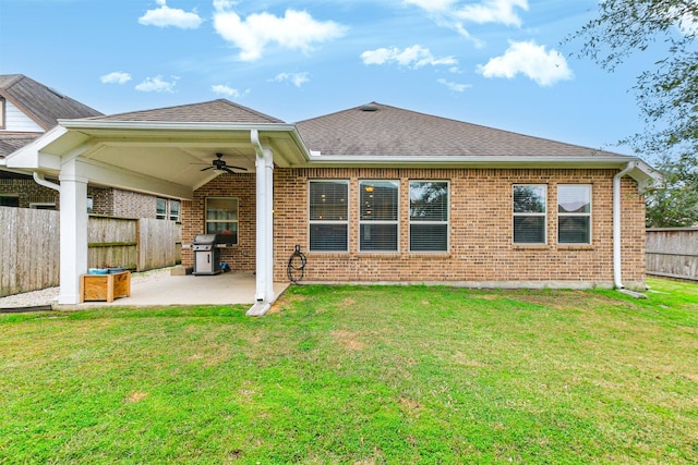 rear view of house featuring ceiling fan, a patio area, and a yard