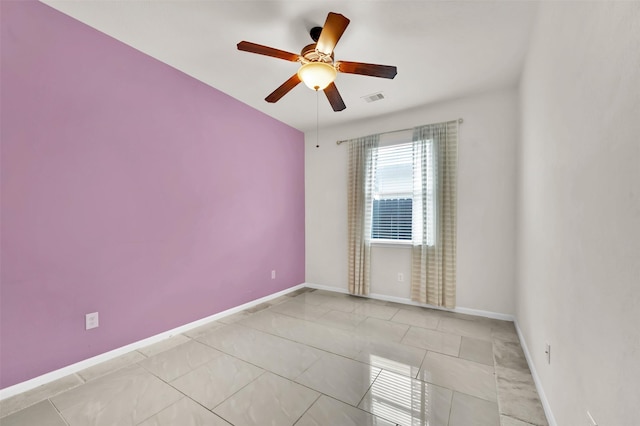 tiled spare room featuring ceiling fan