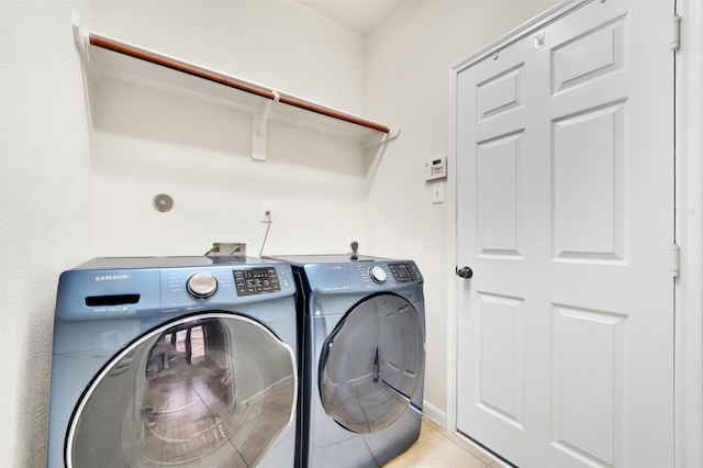 clothes washing area featuring light tile patterned flooring and washing machine and clothes dryer