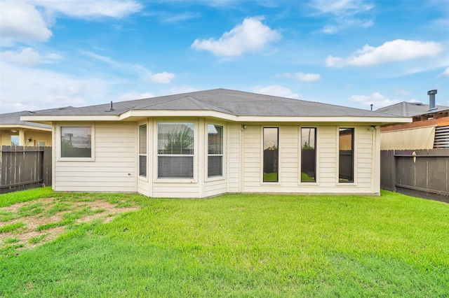 rear view of property with a lawn