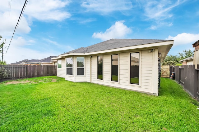 rear view of house featuring a yard