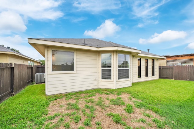 rear view of property with a lawn and central AC unit