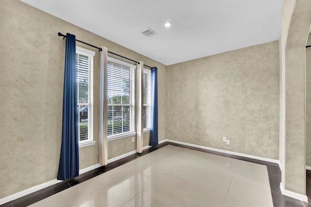 spare room with tile patterned flooring and plenty of natural light