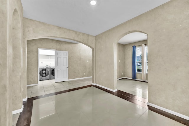 foyer entrance with light tile patterned flooring and washer and dryer