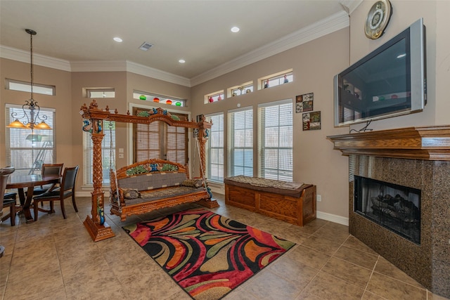 interior space with a chandelier, tile patterned floors, crown molding, and a fireplace