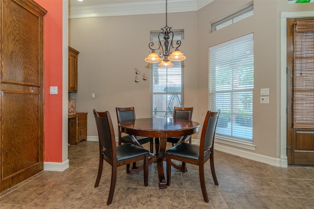 dining room with an inviting chandelier, ornamental molding, and tile patterned floors