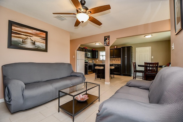 living room featuring light tile patterned flooring and ceiling fan