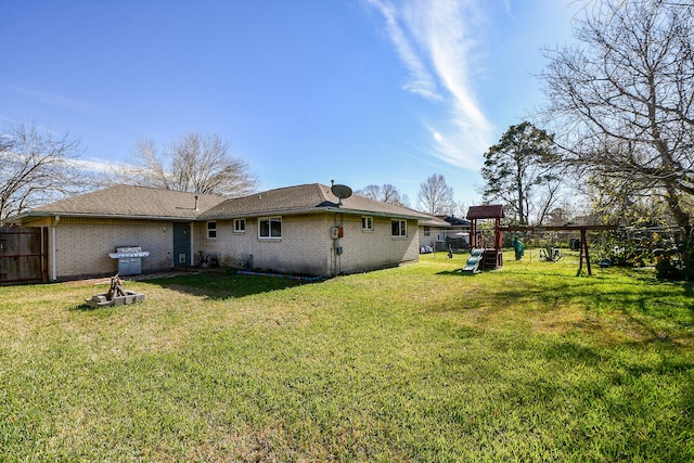 rear view of property with a yard and a playground