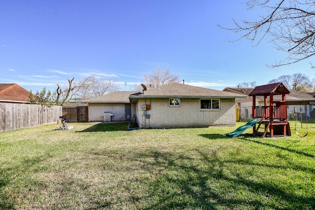 back of property featuring a yard and a playground