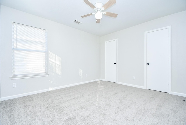 carpeted spare room featuring ceiling fan