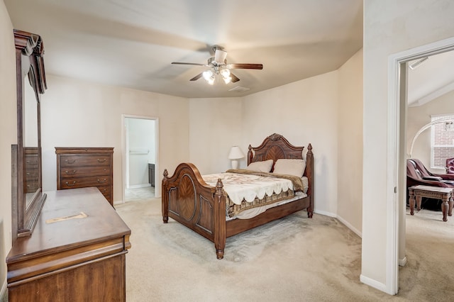 bedroom featuring ceiling fan, light colored carpet, and ensuite bath