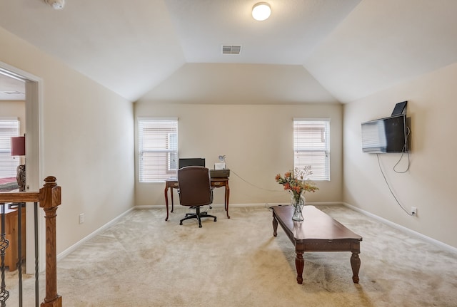 home office featuring light colored carpet, vaulted ceiling, and plenty of natural light