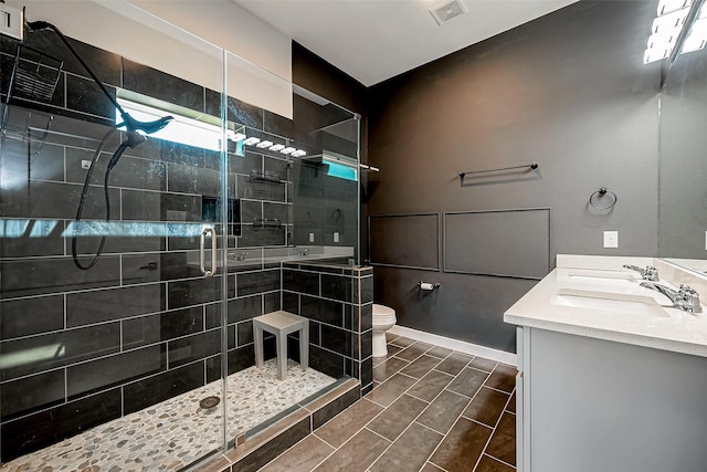 bathroom with toilet, an enclosed shower, and vanity