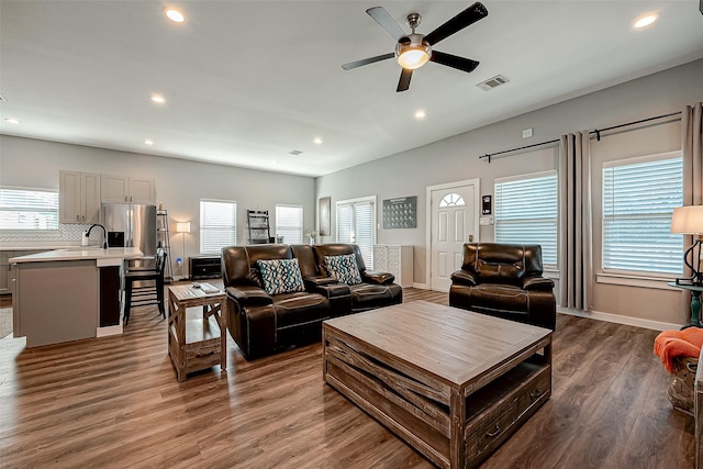 living room featuring sink, ceiling fan, hardwood / wood-style flooring, and a healthy amount of sunlight