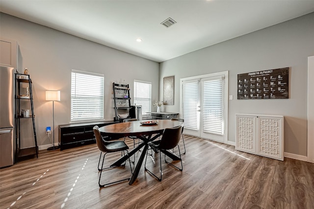 dining room with french doors, hardwood / wood-style floors, and a healthy amount of sunlight