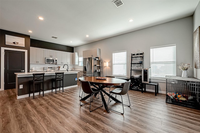 dining room featuring sink, a wealth of natural light, and hardwood / wood-style floors