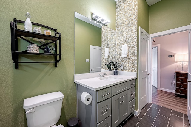 bathroom with toilet, vanity, and tile patterned floors