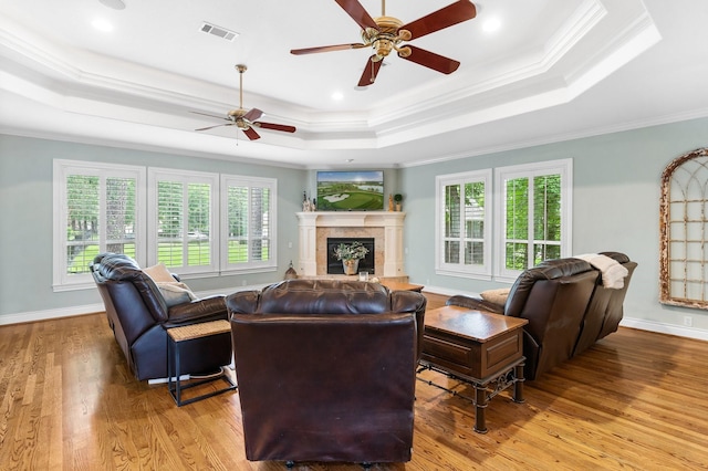 living room featuring ornamental molding, a wealth of natural light, and a tray ceiling