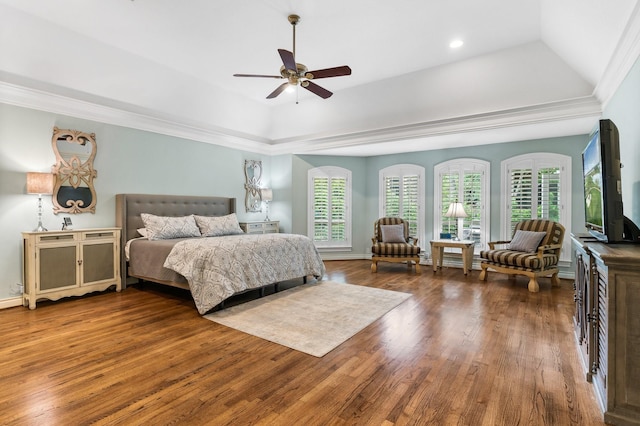 bedroom featuring hardwood / wood-style flooring, a raised ceiling, ceiling fan, and multiple windows