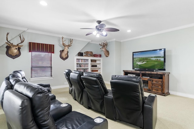 carpeted cinema room with ceiling fan and crown molding