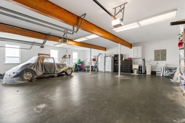 garage featuring electric panel, white refrigerator, and a garage door opener