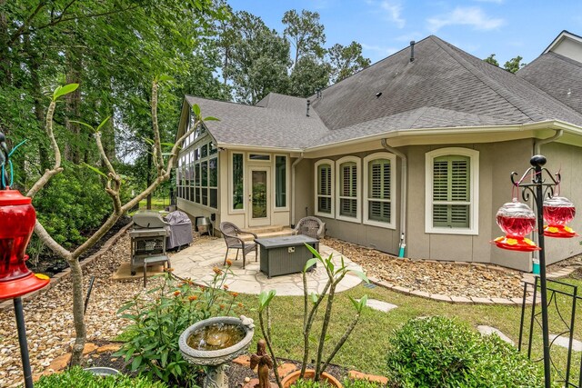 rear view of property with an outdoor fire pit and a patio