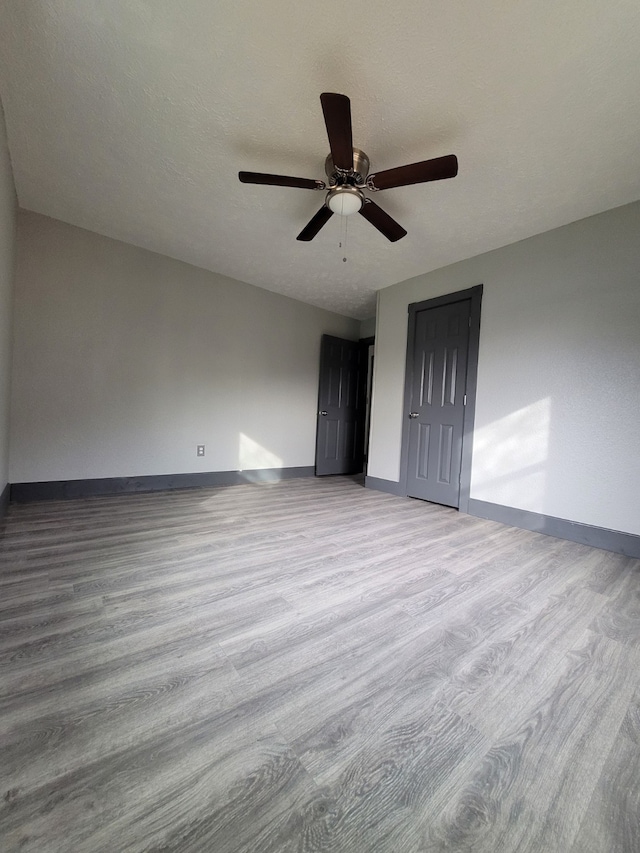 unfurnished bedroom with ceiling fan, a closet, and light wood-type flooring