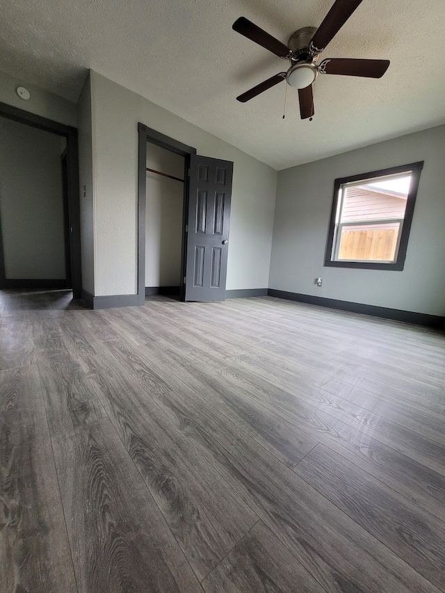 interior space with ceiling fan, wood-type flooring, and a textured ceiling