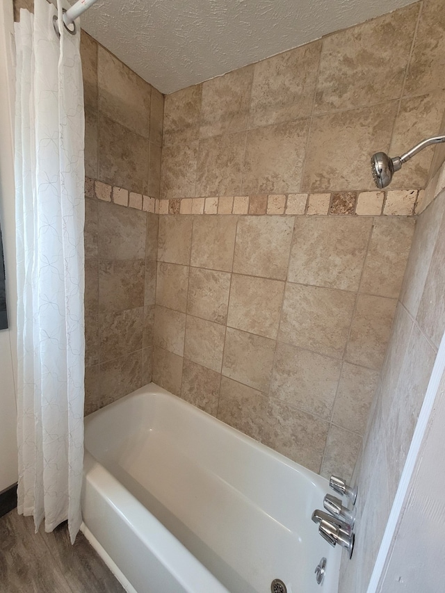 bathroom featuring shower / tub combo, a textured ceiling, and hardwood / wood-style floors