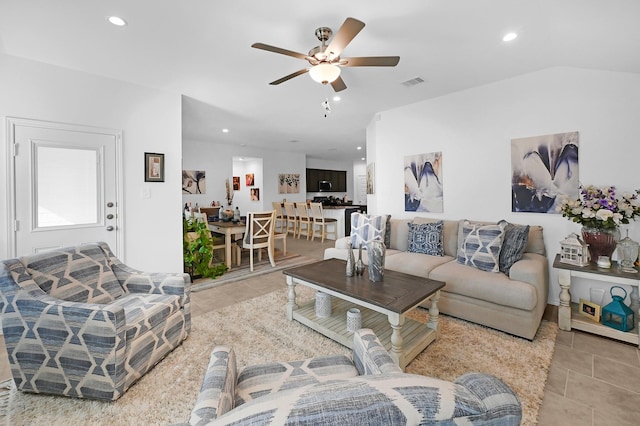 tiled living room featuring ceiling fan and vaulted ceiling