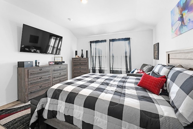 bedroom with multiple windows and lofted ceiling