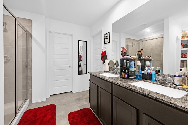 bathroom featuring a shower with shower door and vanity