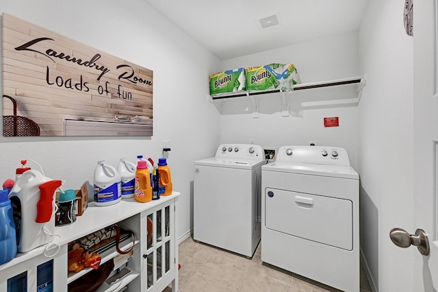 laundry room with washer and dryer and light tile patterned floors