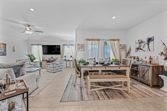 tiled dining area featuring ceiling fan and bar area