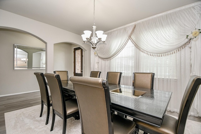 dining area with hardwood / wood-style flooring and a notable chandelier