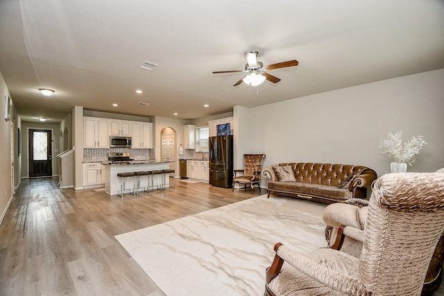 living room featuring ceiling fan and light hardwood / wood-style flooring