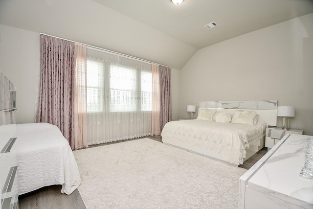 bedroom with lofted ceiling and hardwood / wood-style floors