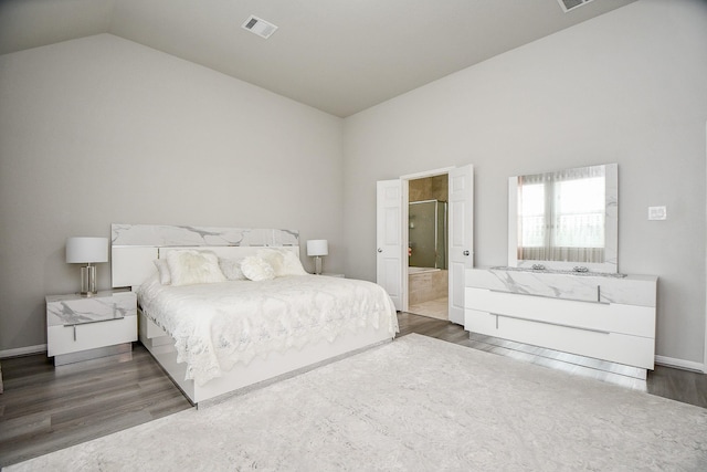 bedroom featuring high vaulted ceiling, dark wood-type flooring, and connected bathroom