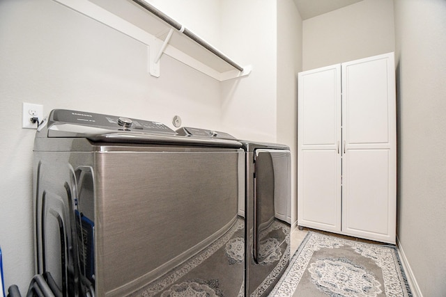 washroom featuring independent washer and dryer and cabinets