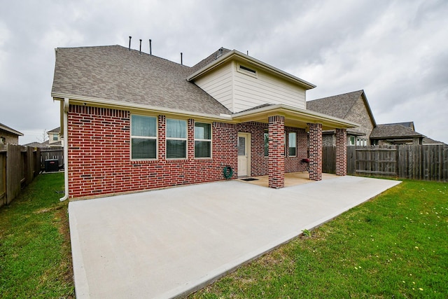 back of house with a yard and a patio