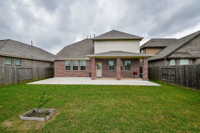 rear view of property with a yard and a patio