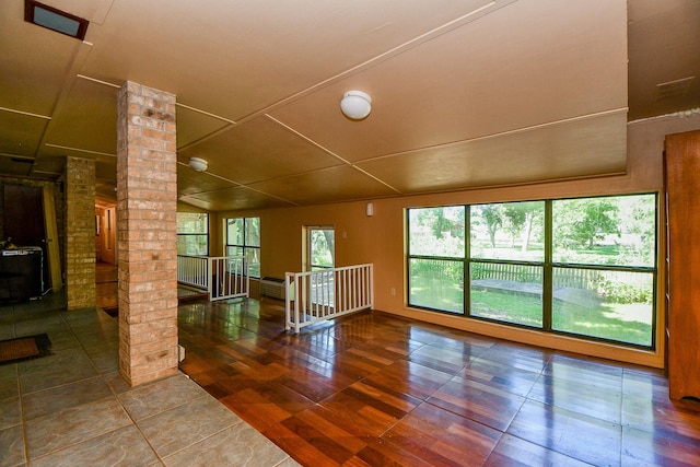 unfurnished room with hardwood / wood-style flooring and decorative columns