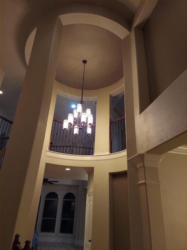 interior space with ceiling fan with notable chandelier