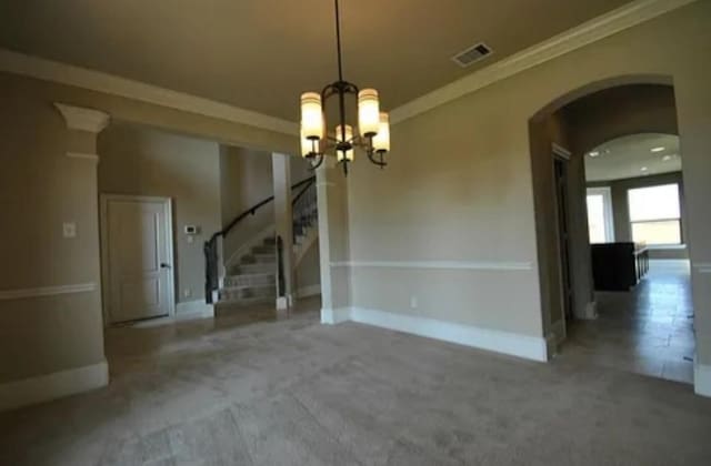 unfurnished dining area with an inviting chandelier, carpet flooring, and crown molding