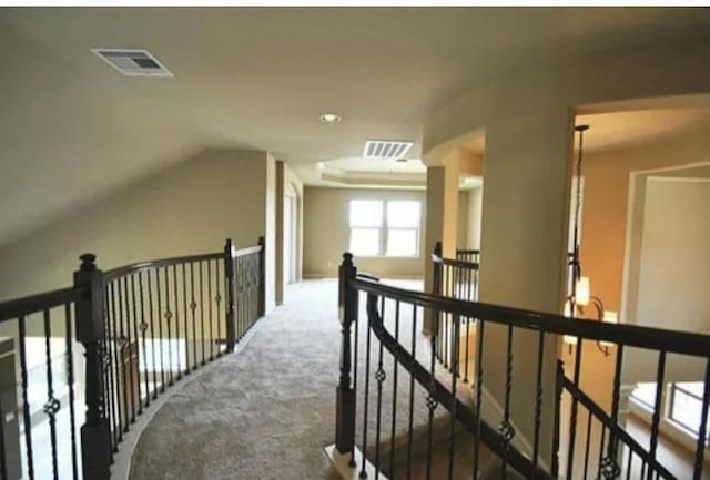 corridor featuring vaulted ceiling and carpet floors